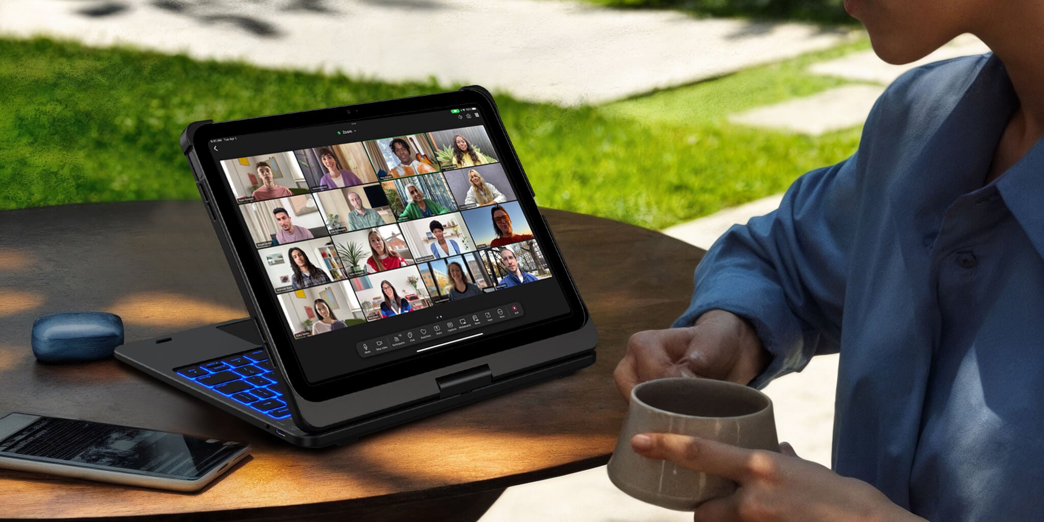 A working woman is leisurely conducting a video conference under a tree using her iPad with a Typecase keyboard cover.